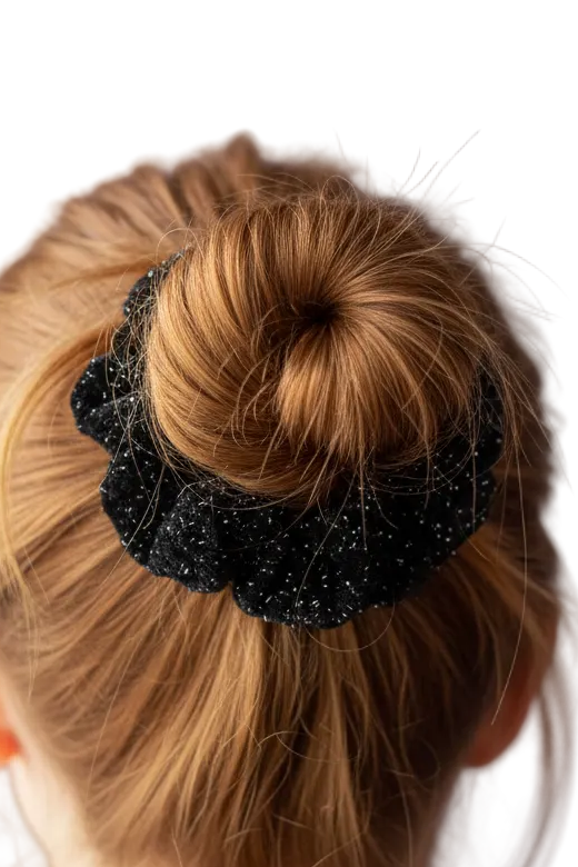 Woman with red hair in messy bun wearing black sparkle scrunchie