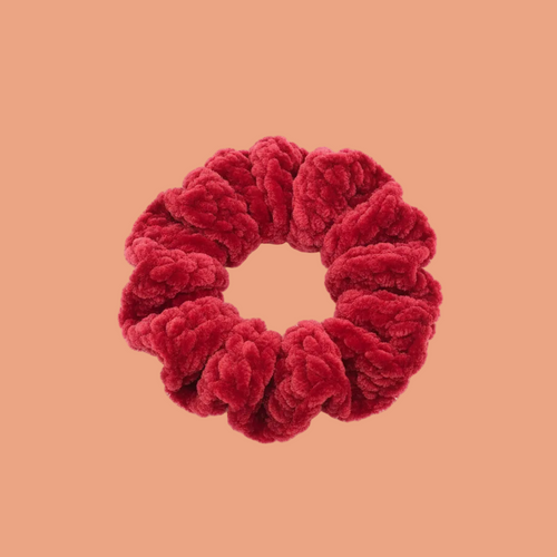 Vibrant cherry red velvet scrunchie on white background